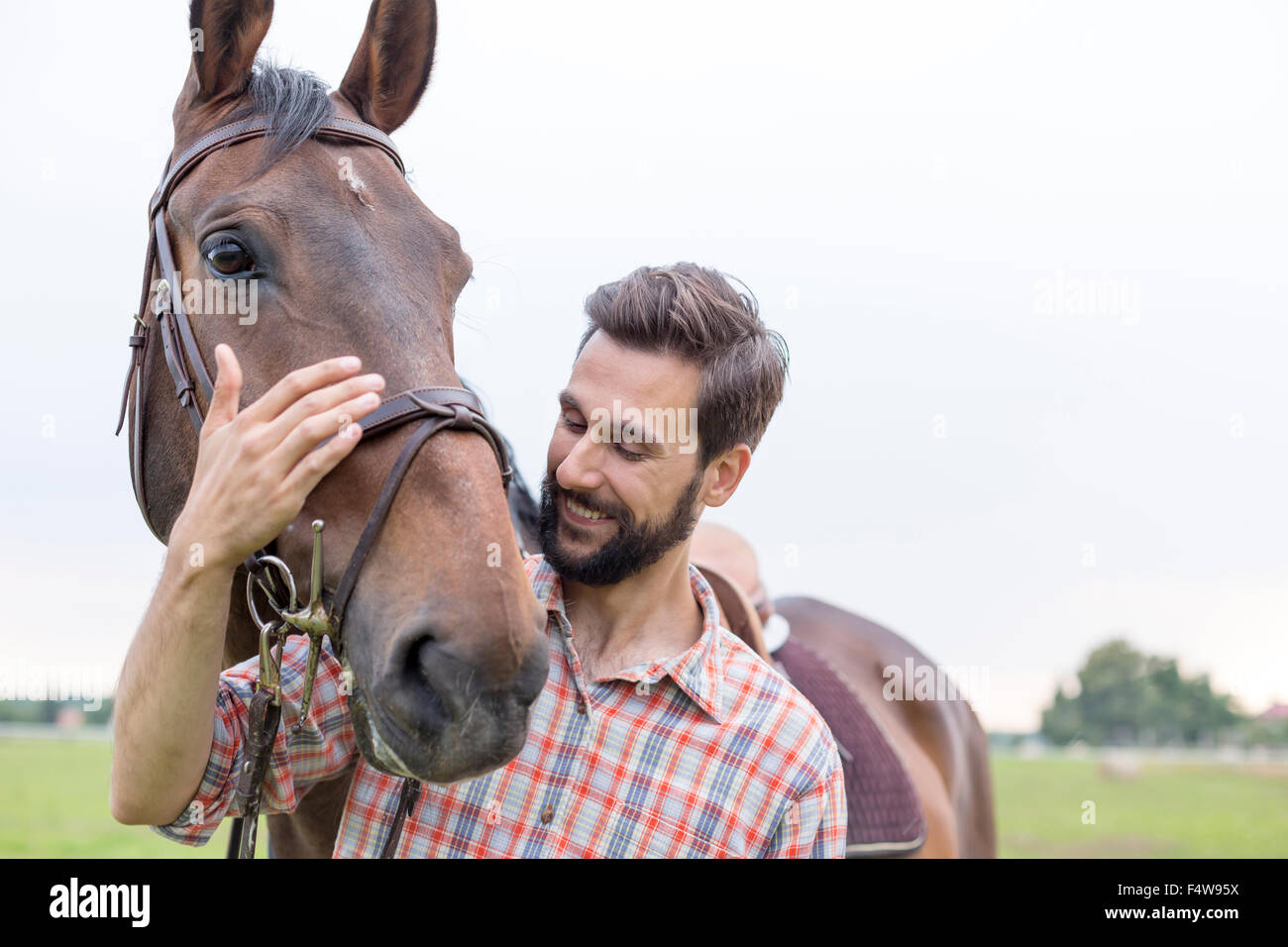 Lächelnd Mann umarmt Pferd Stockfoto