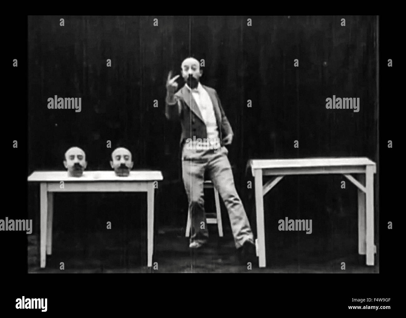 Noch aus un Homme de Têtes ("die vier lästigen Heads") Stummfilm 1898 Darsteller veröffentlicht und unter der Regie von Georges Méliès (1861-1938). In diesem kurzen Méliès experimentiert mit Spezialeffekten in der Kamera mittels Doppelbelichtung Überlagerung; es ihm ermöglicht, seinen Kopf 3 Mal entfernen und dafür dann beitreten ihm in Lied, während er ein Banjo spielt. (3 von 7) Stockfoto