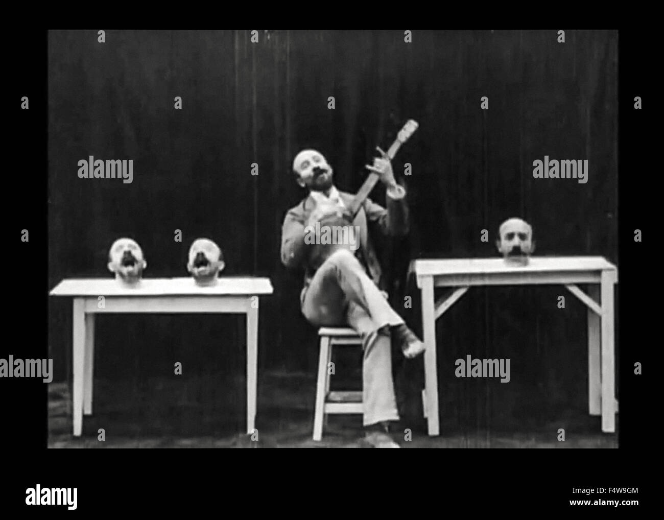 Noch aus un Homme de Têtes ("die vier lästigen Heads") Stummfilm 1898 Darsteller veröffentlicht und unter der Regie von Georges Méliès (1861-1938). In diesem kurzen Méliès experimentiert mit Spezialeffekten in der Kamera mittels Doppelbelichtung Überlagerung; es ihm ermöglicht, seinen Kopf 3 Mal entfernen und dafür dann beitreten ihm in Lied, während er ein Banjo spielt. (7 von 7) Stockfoto