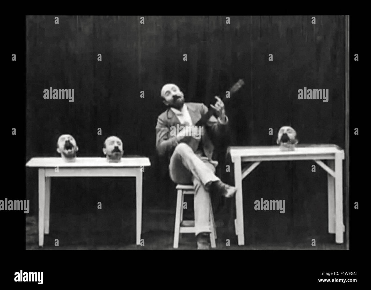 Noch aus un Homme de Têtes ("die vier lästigen Heads") Stummfilm 1898 Darsteller veröffentlicht und unter der Regie von Georges Méliès (1861-1938). In diesem kurzen Méliès experimentiert mit Spezialeffekten in der Kamera mittels Doppelbelichtung Überlagerung; es ihm ermöglicht, seinen Kopf 3 Mal entfernen und dafür dann beitreten ihm in Lied, während er ein Banjo spielt. (6 von 7) Stockfoto