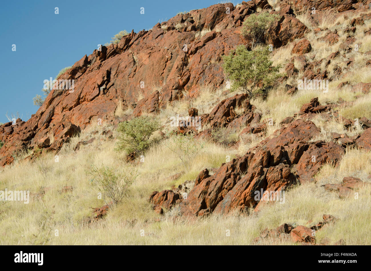 Eisenerz (Hämatit oder Magnetit) erscheint auf der Oberfläche in der Nähe einer Straße in der abgelegenen Bergbaustadt Karratha, Westaustralien Stockfoto