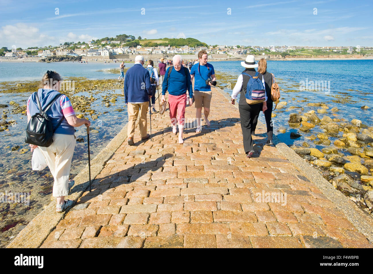 Ein Blick auf die Menschen zu Fuß zum und vom St. Michaels Mount entlang der Damm mit der Stadt von Marazion im Hintergrund. Stockfoto