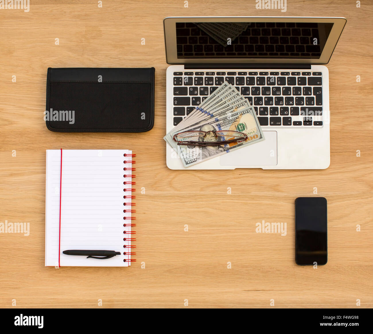 Business-Konzept - Laptop, Banknoten der us-Dollar, Visitenkarten-Etui, Smartphone und geöffneten Notizblock mit Stift. Draufsicht der t Stockfoto