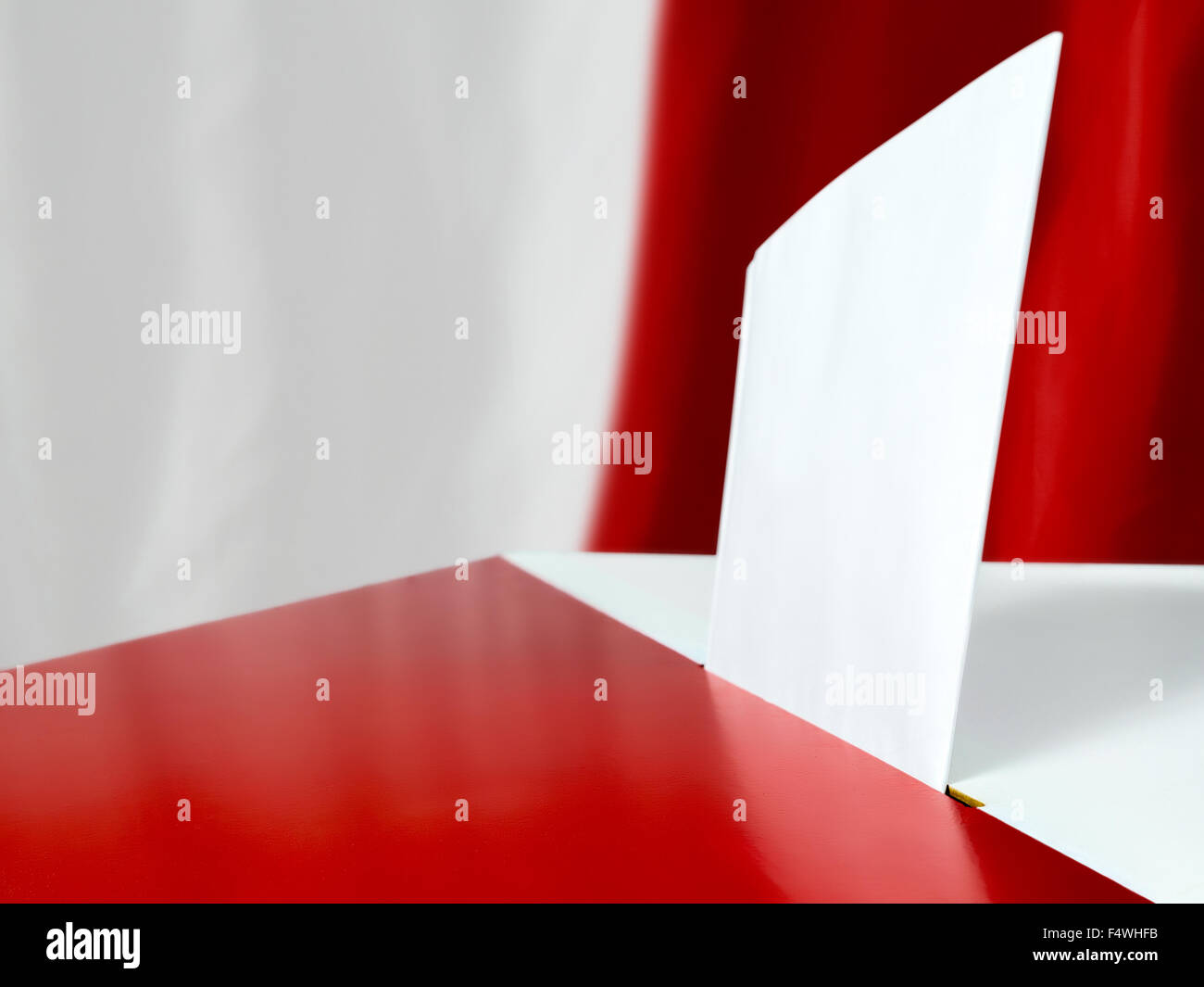 Stimmkarte in die Wahlurne gegen polnische Flagge als Hintergrund Stockfoto