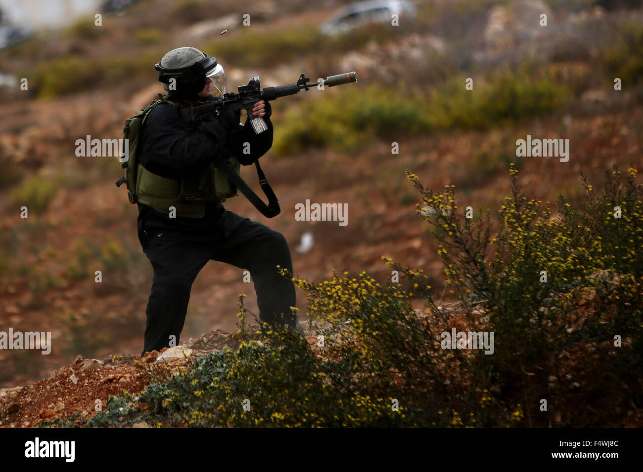 Ramallah, Westjordanland, Palästinensische Gebiete. 23. Oktober 2015. Eine israelische Grenzpolizei feuert gegen palästinensische Demonstranten bei Zusammenstößen in der Nähe der jüdischen Siedlung von Beit El, in der Nähe von Ramallah am 23. Oktober 2015. Palästinensischen Fraktionen gefordert Massenkundgebungen gegen Israel in den besetzten Westjordanland und Ostjerusalem in einen '' Tag des Zorns '' am Freitag, als Welt und regionale Mächte angedrückt mit Vorträgen zu versuchen, mehr als drei Wochen des Blutvergießens Credit Ende: Shadi Hatem/APA Bilder/ZUMA Draht/Alamy Live News Stockfoto