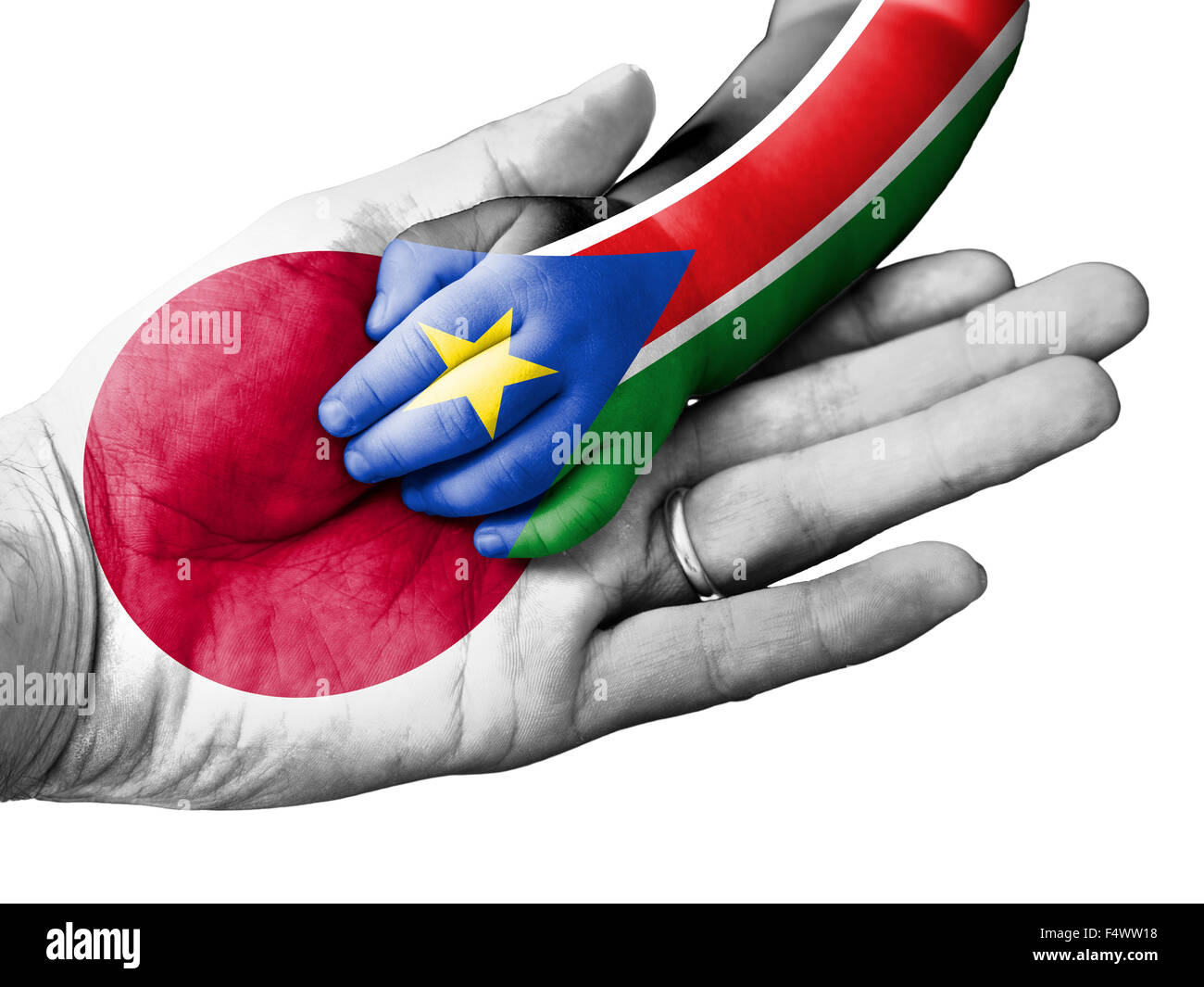 Flagge von Japan überlagert die Hand eines erwachsenen Mannes, die im Besitz einer Baby-Hand mit der Flagge des Südsudan überdruckt. Konzeptbild f Stockfoto