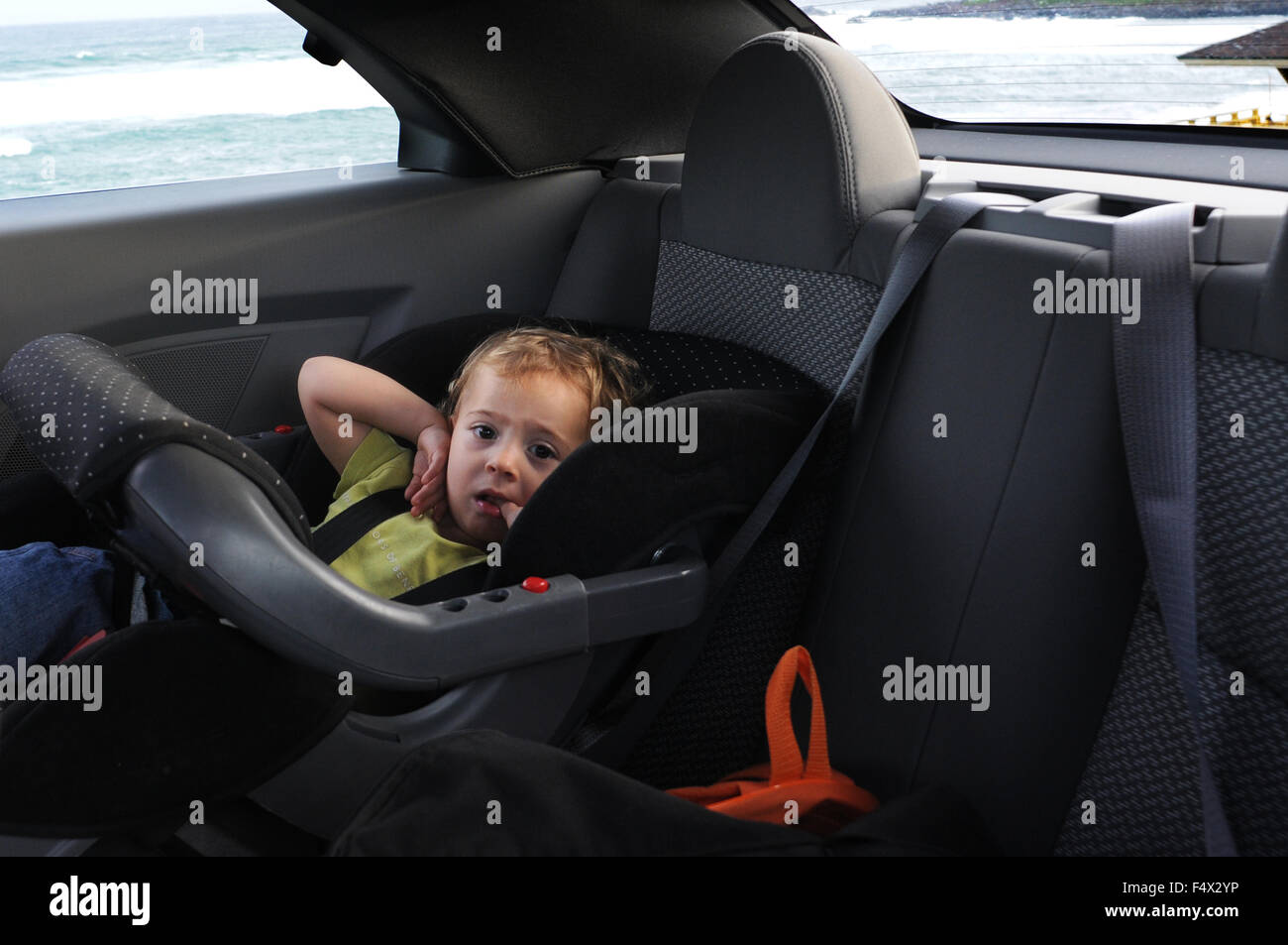 Kind in ein Baby Sitz hinten eines Mietwagens Chrysler Sebring Cabrio in Straße nach Hana. Maui. Hawaii. Oheo Pools Gulch Hana High Stockfoto
