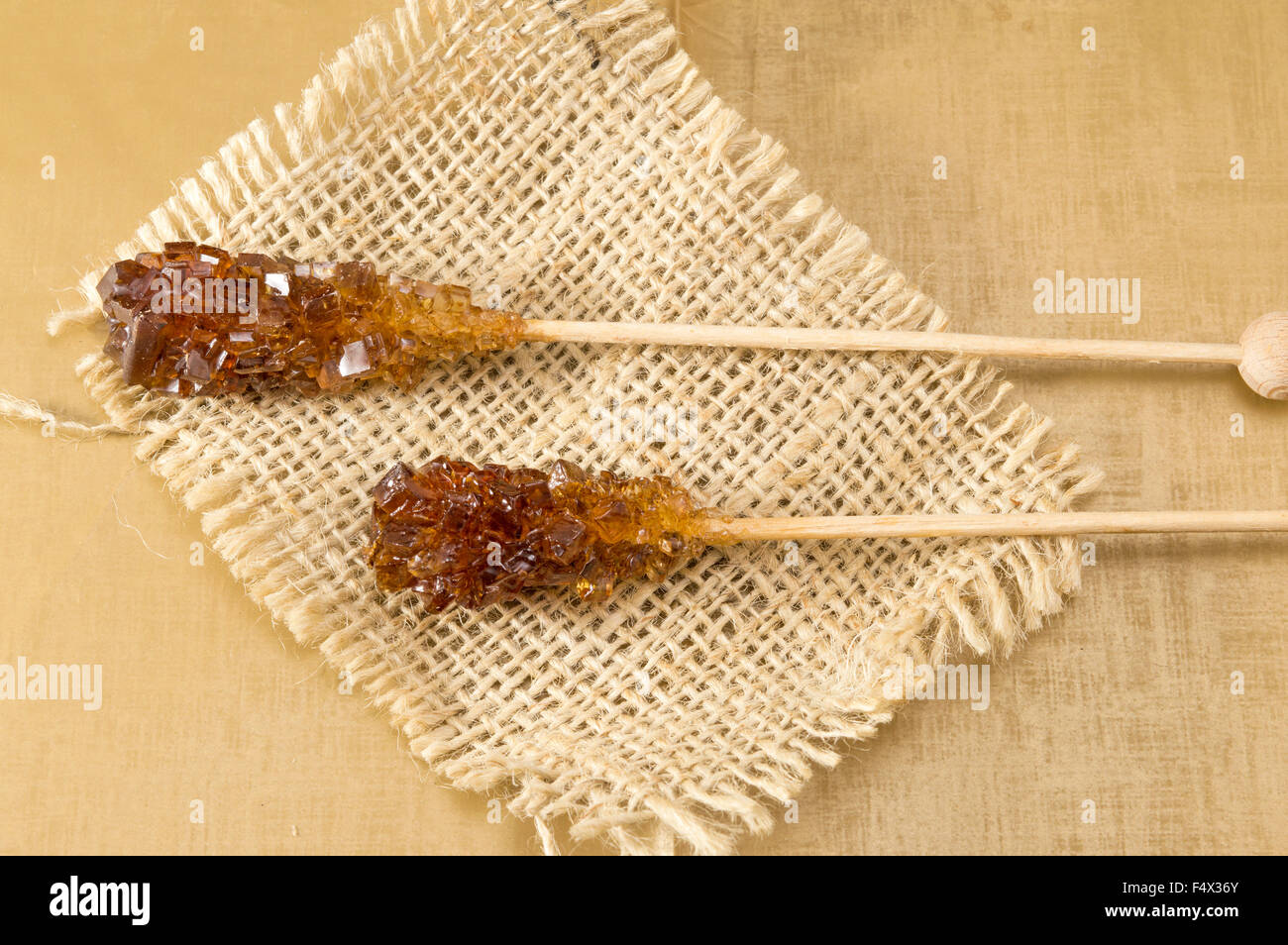 Zwei kristallisierte brauner Zuckersticks auf rustikalen Tischdecke Stockfoto