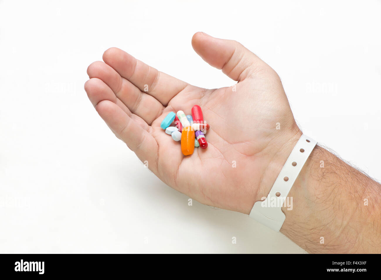 Krankenhauspatienten hält viele verschiedene Medikamente in der Handfläche. Stockfoto