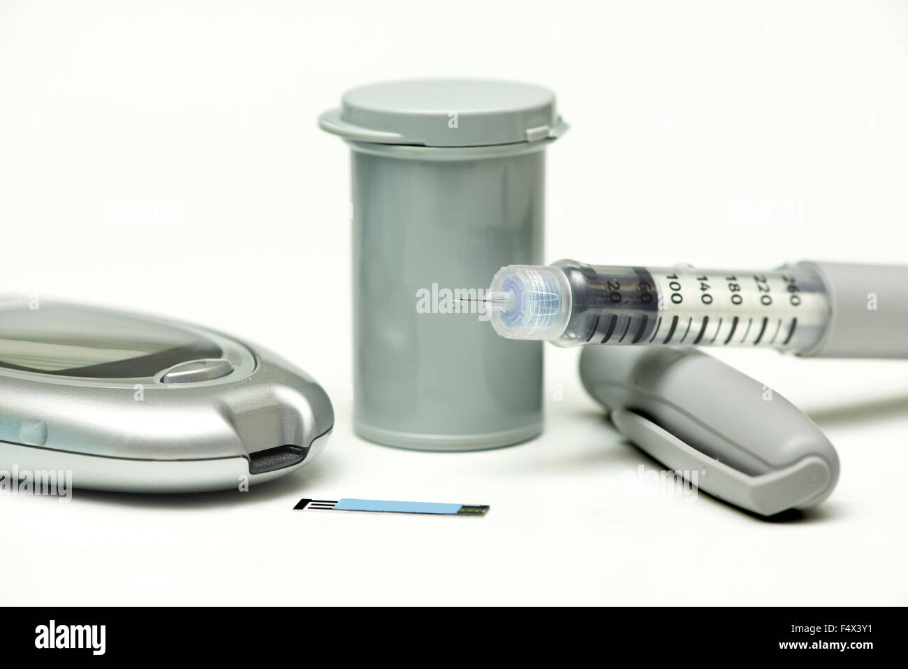 Insulin-Tröpfchen auf Insulin-Pen-Nadel mit Messgerät, Streifen und Kanister. Stockfoto