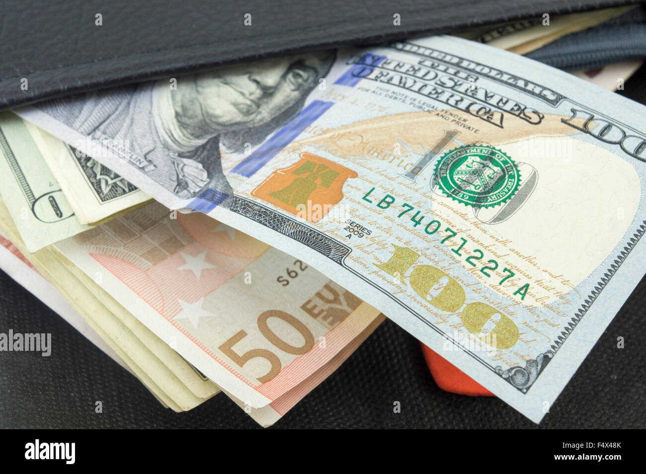 Verschiedenen Euro und Dollar-Scheine in eine schwarze Geldbörse Stockfoto