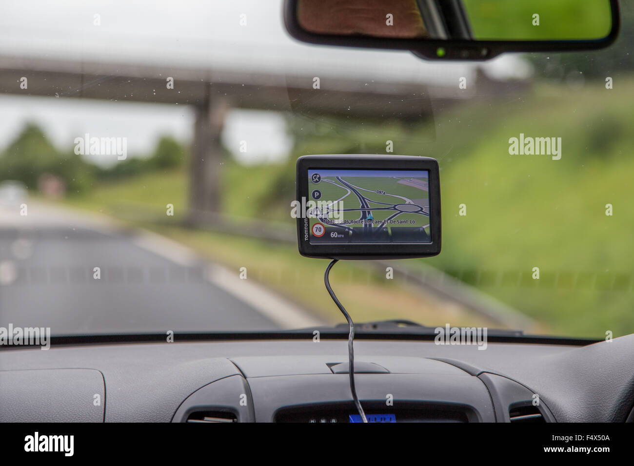 Männliche Fahrer mit einem Navi (Satelliten-Navigationsgerät) an einer Hauptstraße in UK Stockfoto