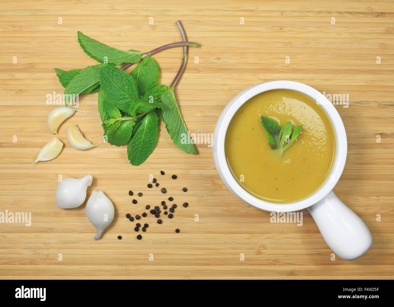 Eine Schüssel mit Eichel-Kürbis-Suppe auf einem Holztisch. Stockfoto