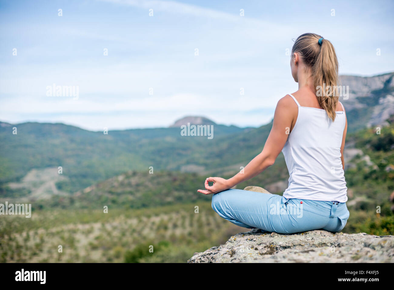Blonde Frau beim Yoga in den Bergen Stockfoto
