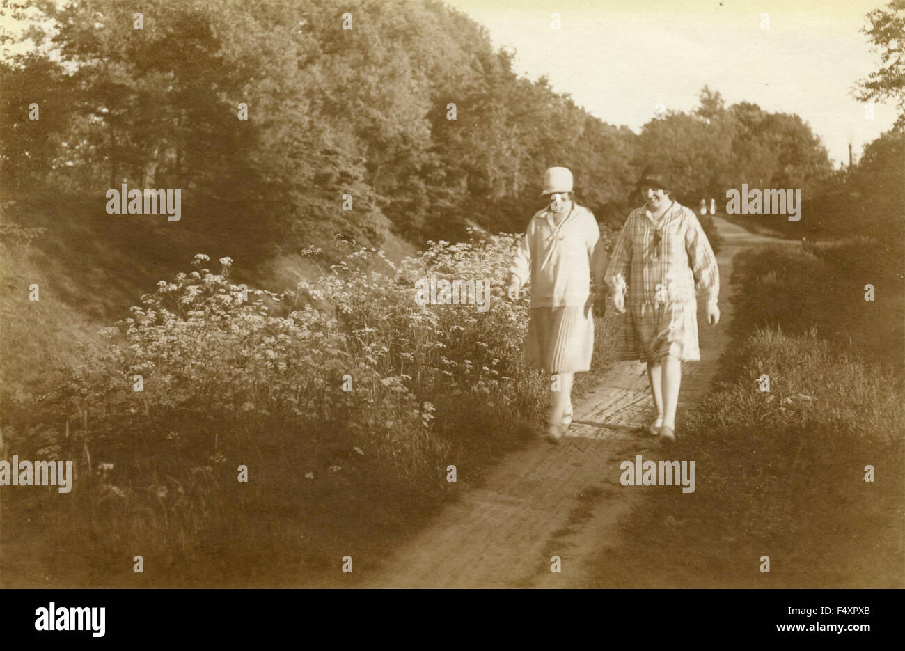 Zwei Frauen mit Hut zu Fuß auf einer Landstraße, Dänemark Stockfoto