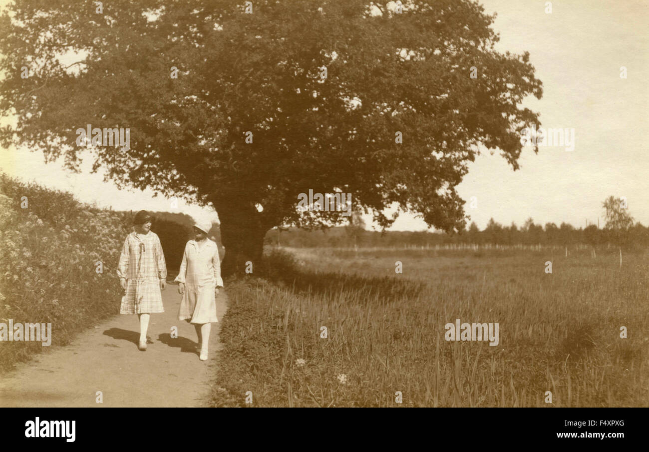 Zwei Frauen mit Hut zu Fuß auf einer Landstraße, Dänemark Stockfoto