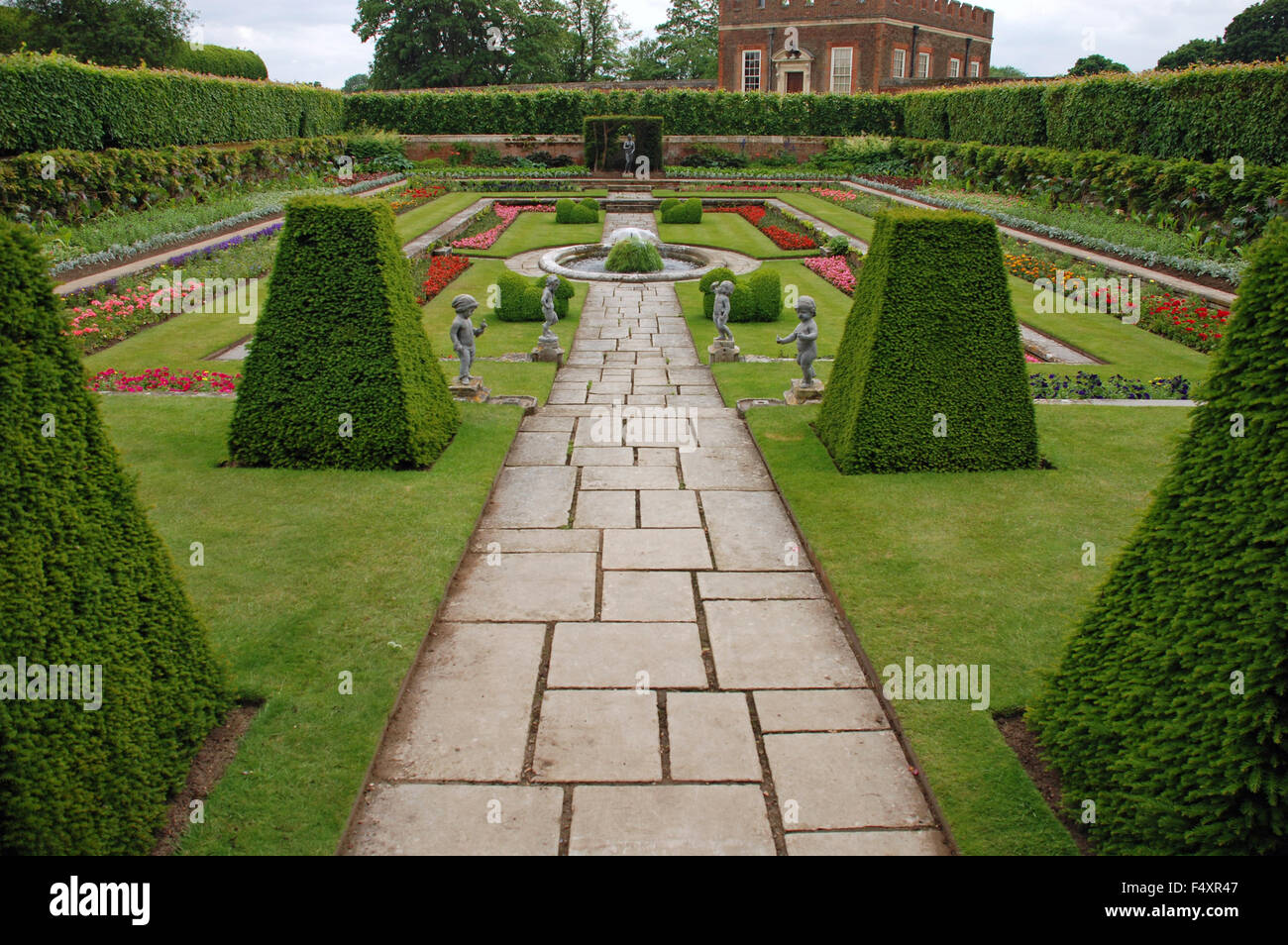 Symmetrische Gartenanlage gestutzte Hecke Formschnitt Stein Felsenpfad und Skulpturen in Hampton Court Palace, London, England Stockfoto