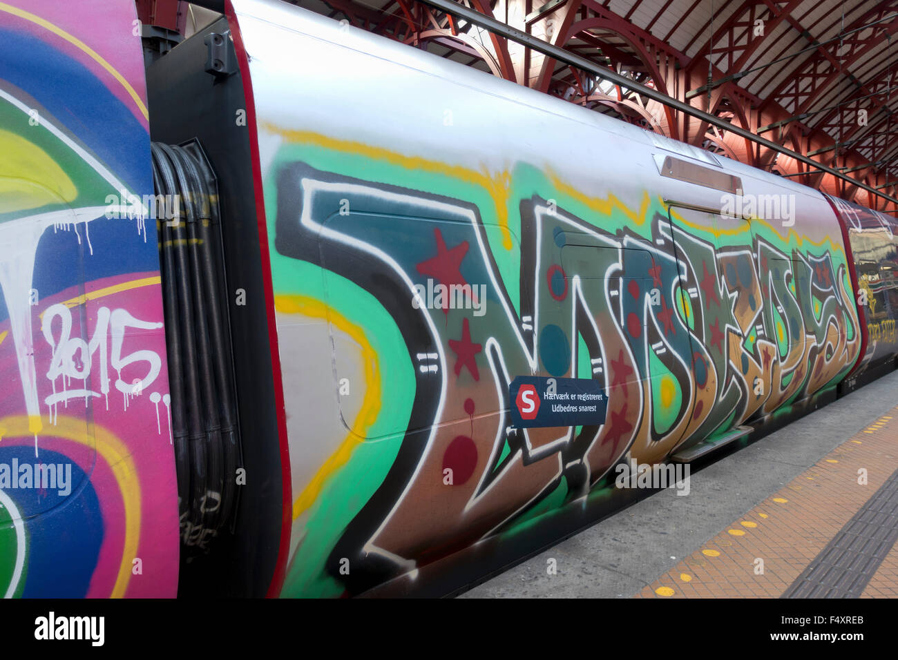 Graffiti vandalises völlig dieser S-Bahn-Wagen. Zug am Bahnsteig am Hauptbahnhof Kopenhagen und noch in Betrieb. Stockfoto