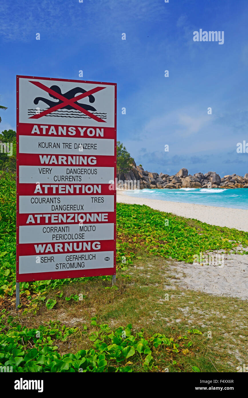 Melden Sie mit Warnung in mehreren Sprachen, gefährliche Strömung, Schwimmen verboten, Grand Anse Strand, La Digue Island, Seychellen Stockfoto