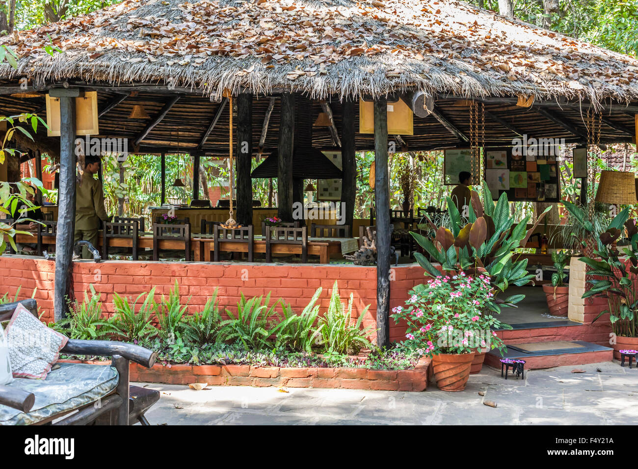 Outdoor-Essbereich unter einem Strohdach in Kanha Jungle Lodge, Madha Pradesh, Indien. Stockfoto