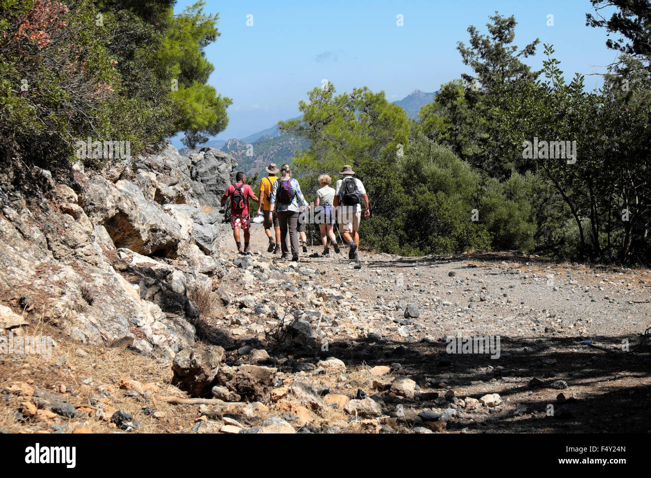 Senioren, walking-Gruppe und Führer zu Fuß entlang der felsigen Landstraße in der Nähe von Kyrenia im türkischen Norden Zyperns KATHY DEWITT Stockfoto
