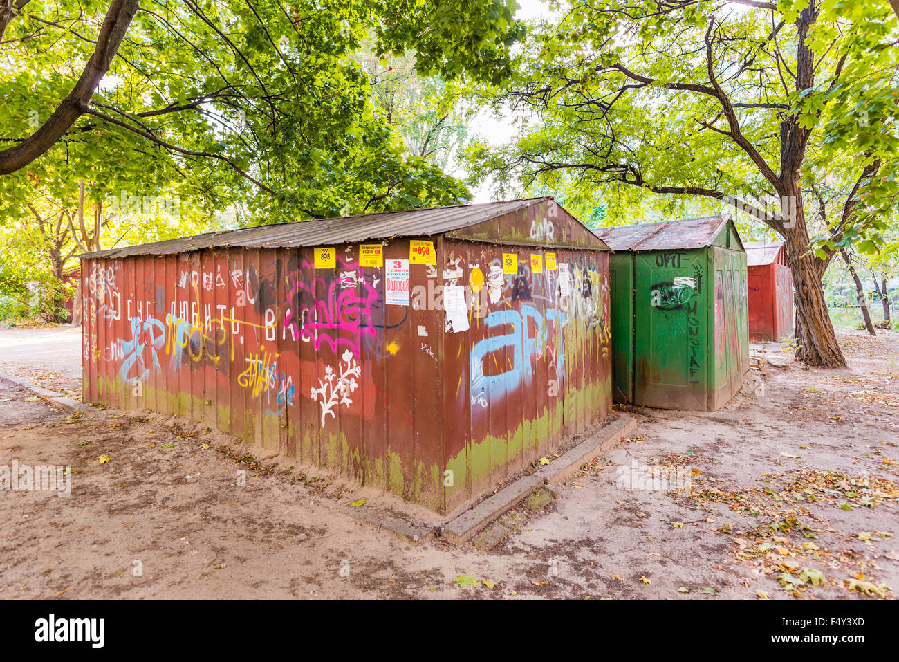 Kiew/Ukraine - 19. September 2015 - alte rostige Garage unter dem Baum mit Graffiti in Kyrillisch, im Stadtteil Obolon Stockfoto