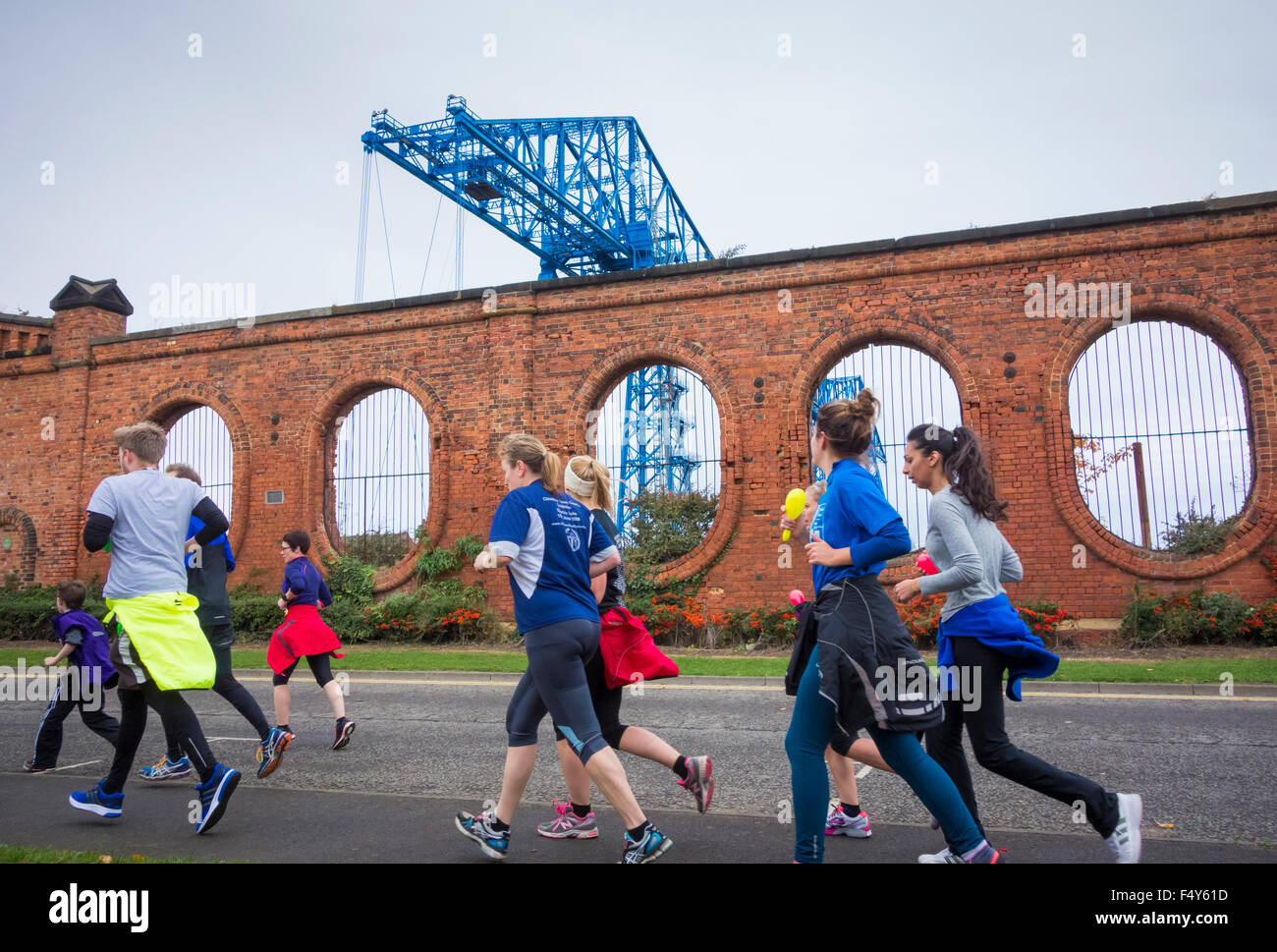 Middlesbrough, UK. 24. Oktober 2015. 2,5 Meile geführte Kunst laufen einige der Middlesbrough Kunsträume und historische Sehenswürdigkeiten zu besuchen. Bild: Läufer nähert sich die Abschläge Schwebefähre. Die Tees Schwebefähre wurde ein Symbol der Gegend seit der Eröffnung im Jahr 1911. In Großbritannien gibt es nur zwei andere Transporter Bridges noch im bestehen. Diese Brücken sind in Newport (Gwent), 1906 eröffnet und Warrington, 1916 eröffnet. Bildnachweis: Alan Dawson News/Alamy Live-Nachrichten Stockfoto