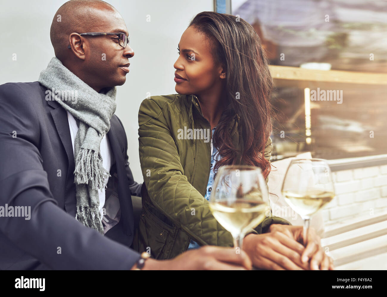 Schwarz Paar mit einem Gespräch in einem Café im Freien im Frühjahr Stockfoto