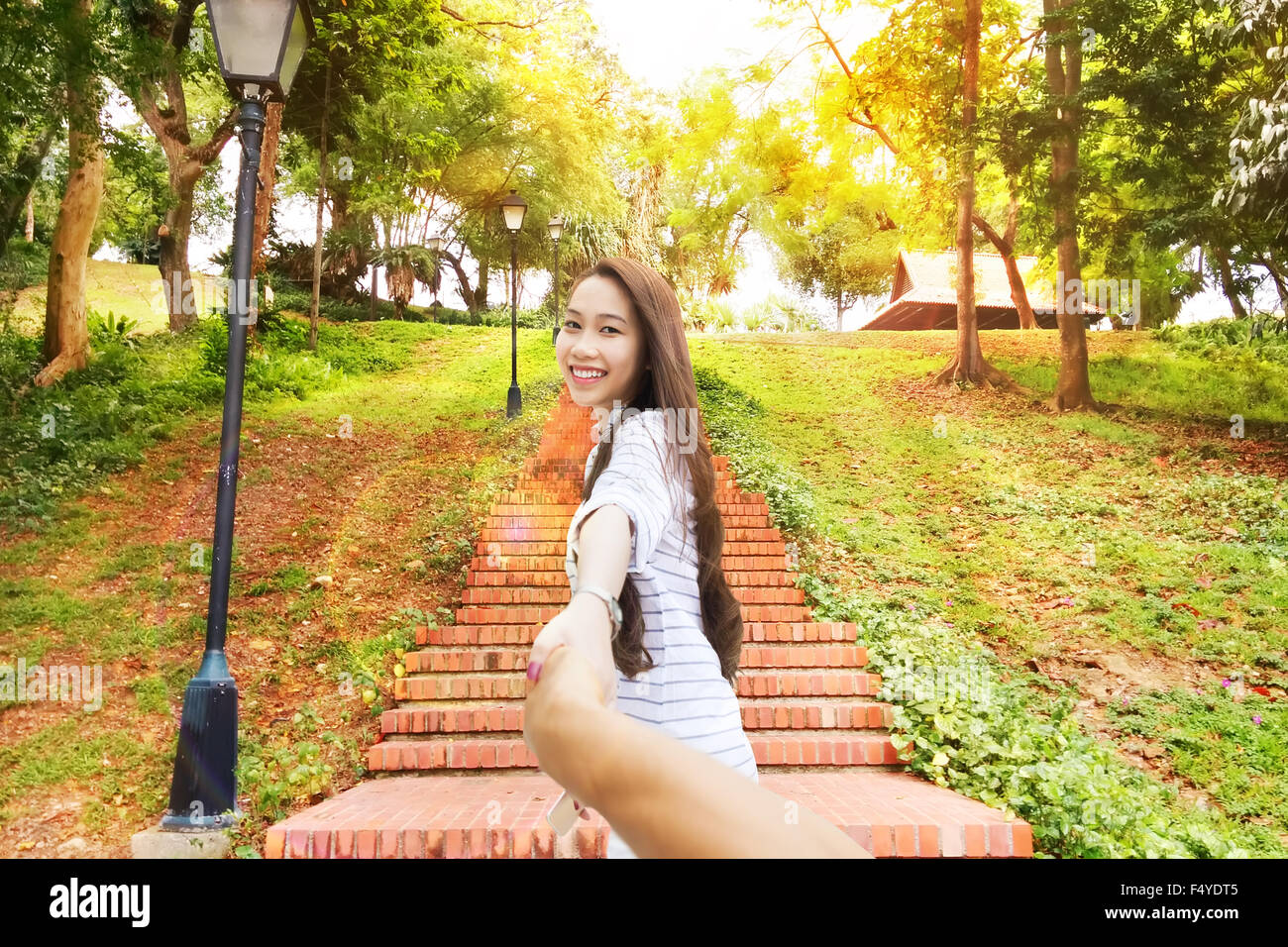 Asiatische Frau folgen Sie mir an Mann Hand glücklich Lächeln grünen Park führt Stockfoto