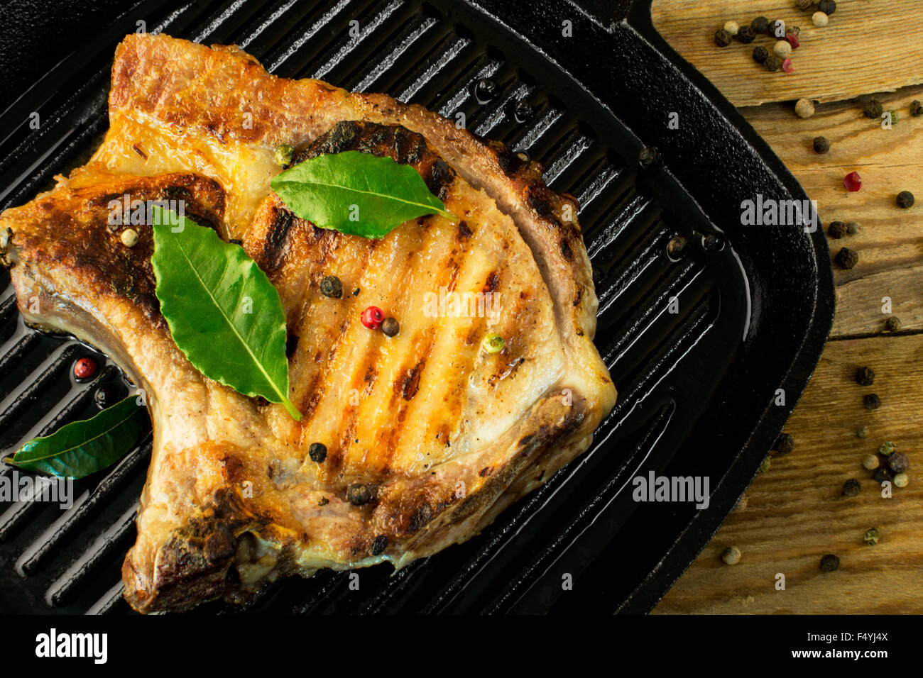 gebratenes Fleisch mit grünen Lorbeerblättern und Pfeffer Körner closeup Stockfoto