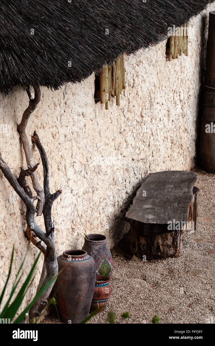 Afrikanisches Dorf outdoor-Szene leer Bank und Töpfe Stroh Dach Stockfoto