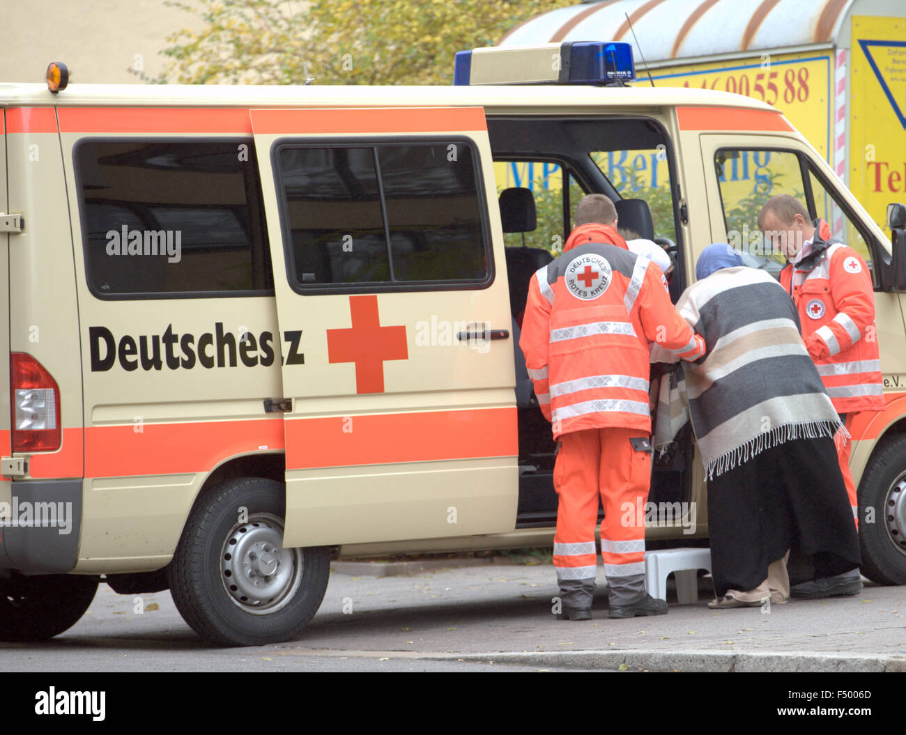 Mitglieder des Deutschen Roten Kreuzes Hilfe eine Frau zu evakuieren ihr Heim während Bombe Entsorgungsverfahren, in Berlin, Deutschland, 25. Oktober 2015. Eine amerikanische 250kg-Bombe aus dem zweiten Weltkrieg wurde auf einer Baustelle in der Nähe des jüdischen Museums gefunden und entschärft werden muss. FOTO: PAUL ZINKEN/DPA Stockfoto