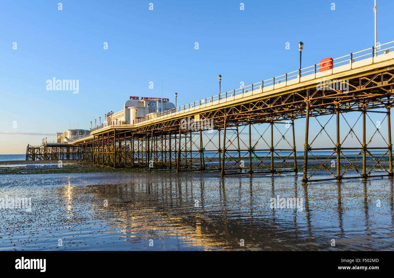 Worthing Pier bei Ebbe am frühen Morgen mit Reflexionen in den nassen Sand, Worthing, West Sussex, England, UK. Stockfoto