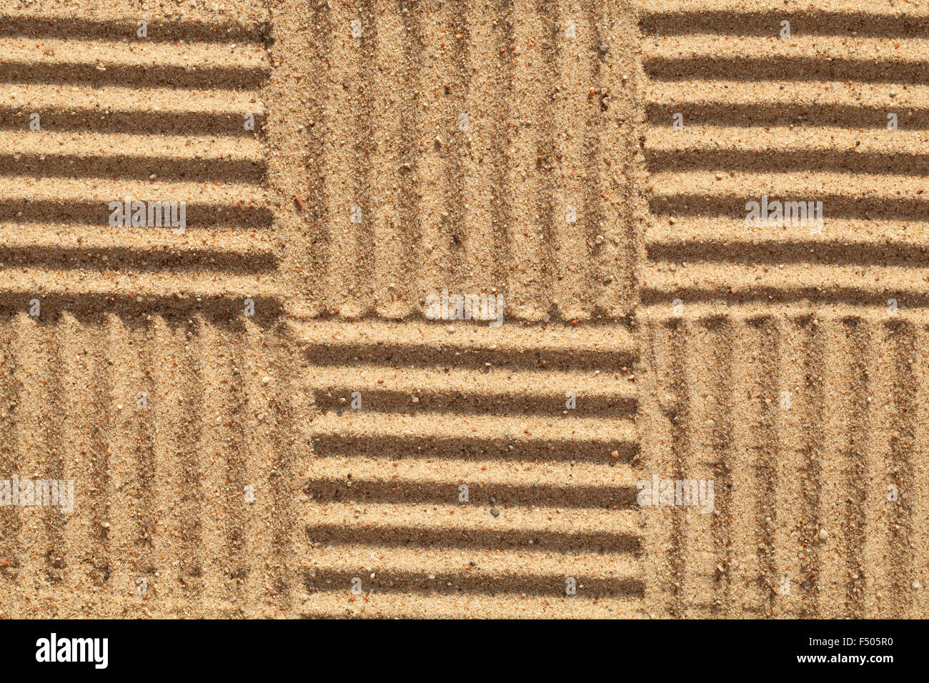 Muster in mit Sand als Hintergrund überprüft Stockfoto