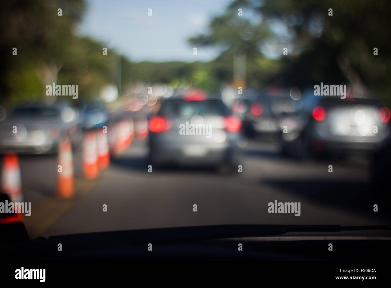 Stau - ein verschwommenes Bild von Bau Kegeln und einer Reihe von Autos bewegt sich langsam durch einen städtischen Straße Stockfoto