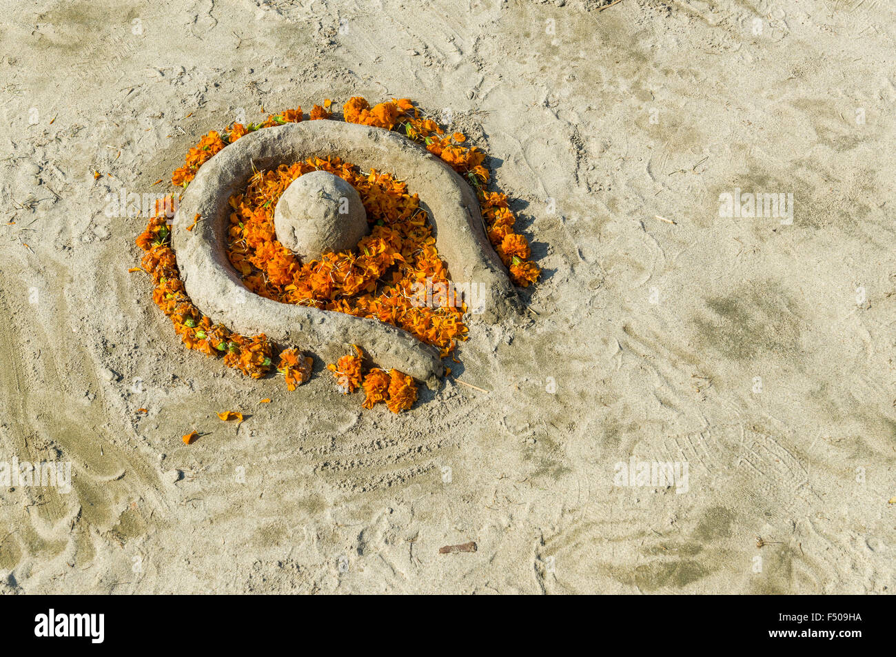 Shiva Lingam aus Sand und Blumen an der sangam, dem Zusammenfluss von Ganges, Yamuna und Saraswati, an Kumbha Mela Stockfoto