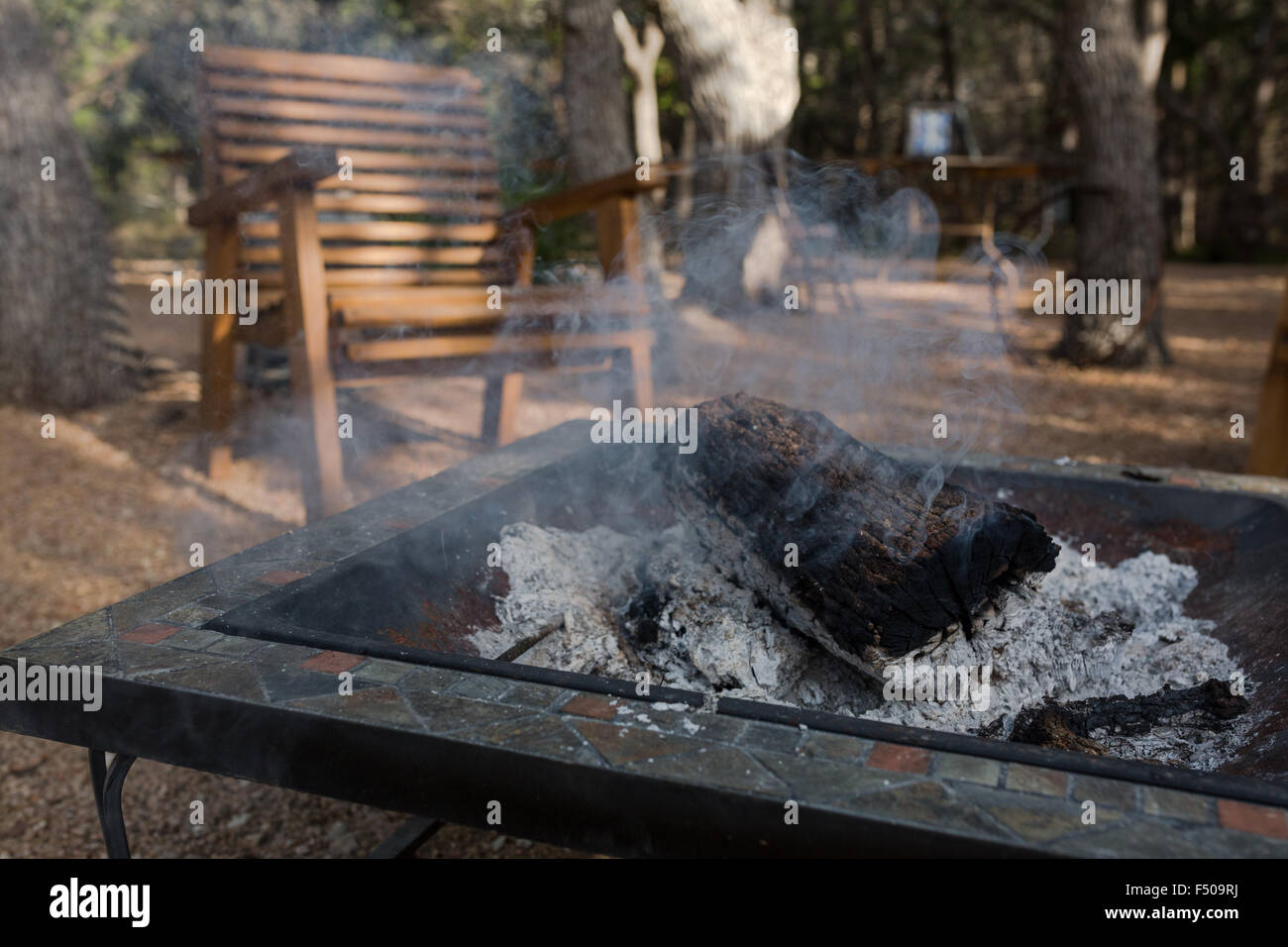 Ein brennendes Feuer auf einem Campingplatz in Texas erloschen, aber immer noch schwelenden log Stockfoto