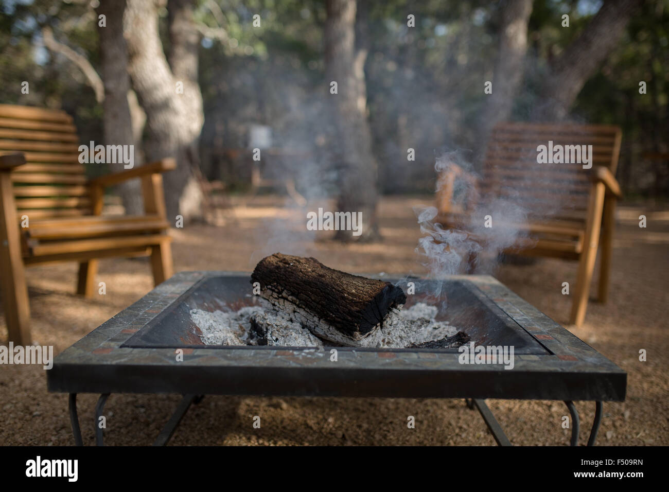 Ein brennendes Feuer auf einem Campingplatz in Texas erloschen, aber immer noch schwelenden log Stockfoto