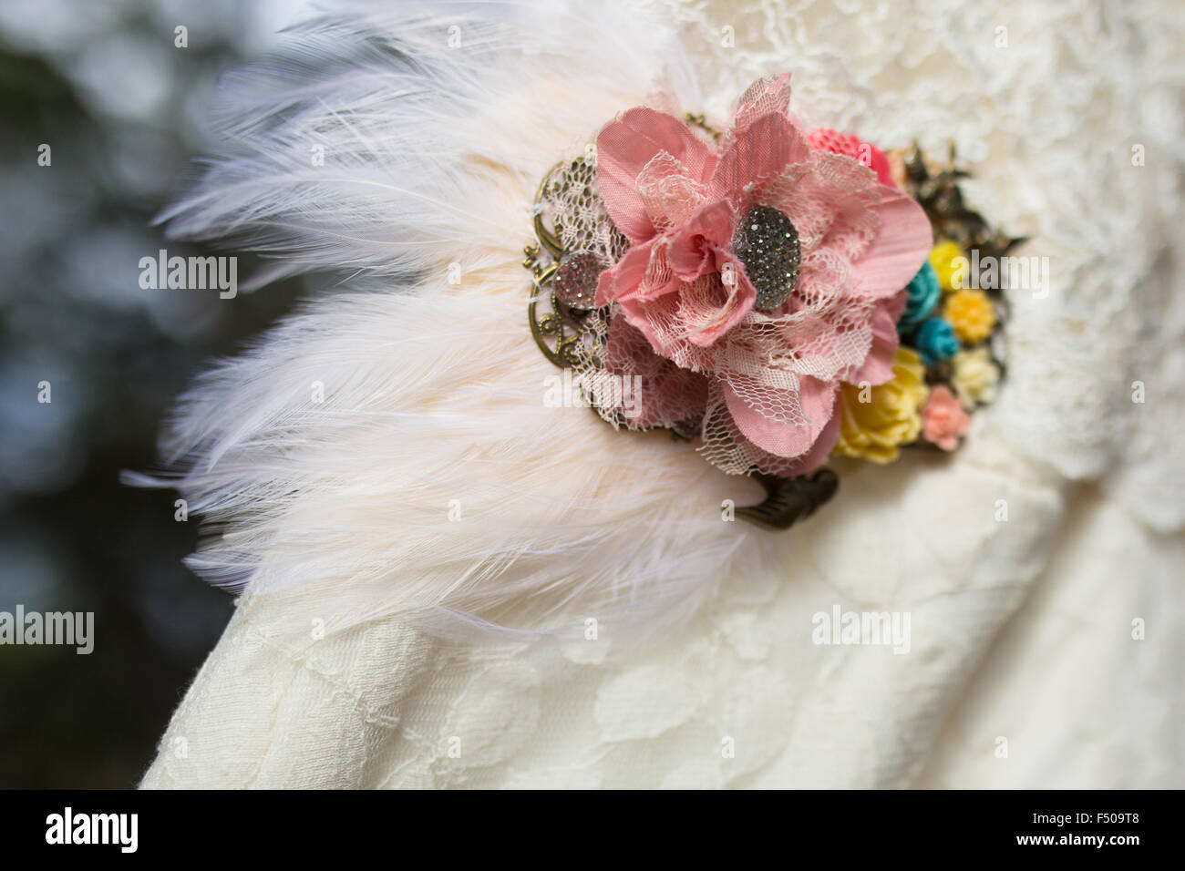 Eine Frau Brosche mit Federn fixiert, ein Hochzeitskleid Stockfoto
