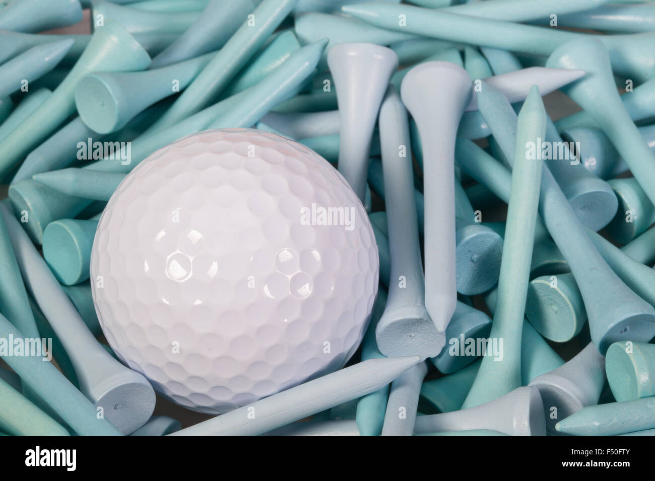 Weiße Golfball liegen zwischen blauen hölzernen Golf-tees Stockfoto