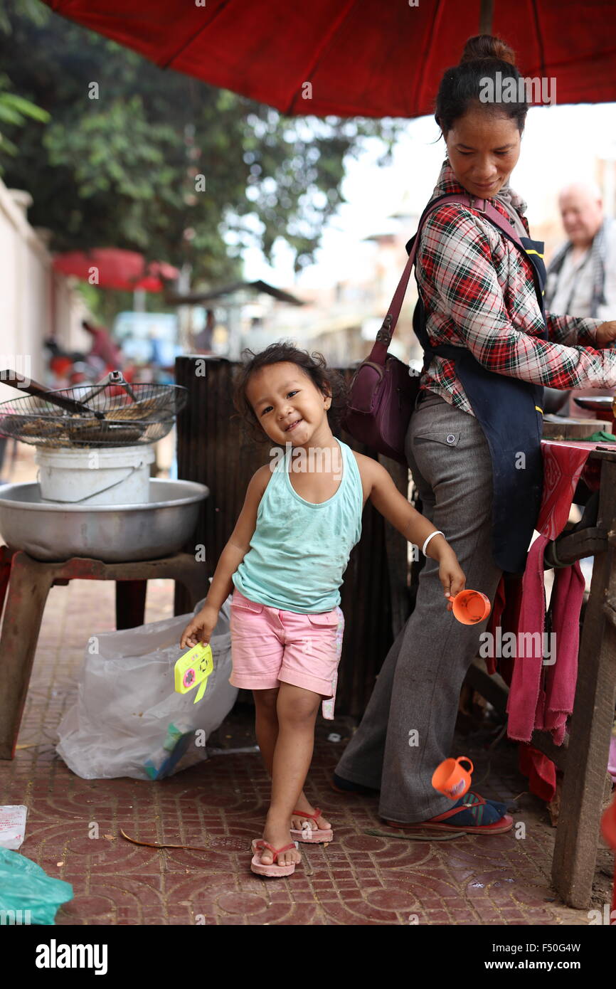 Junge asiatische Mädchen mit ihrer Mutter in Garküche beginnend zu posieren- and -Drop ihre Plastikbecher Stockfoto