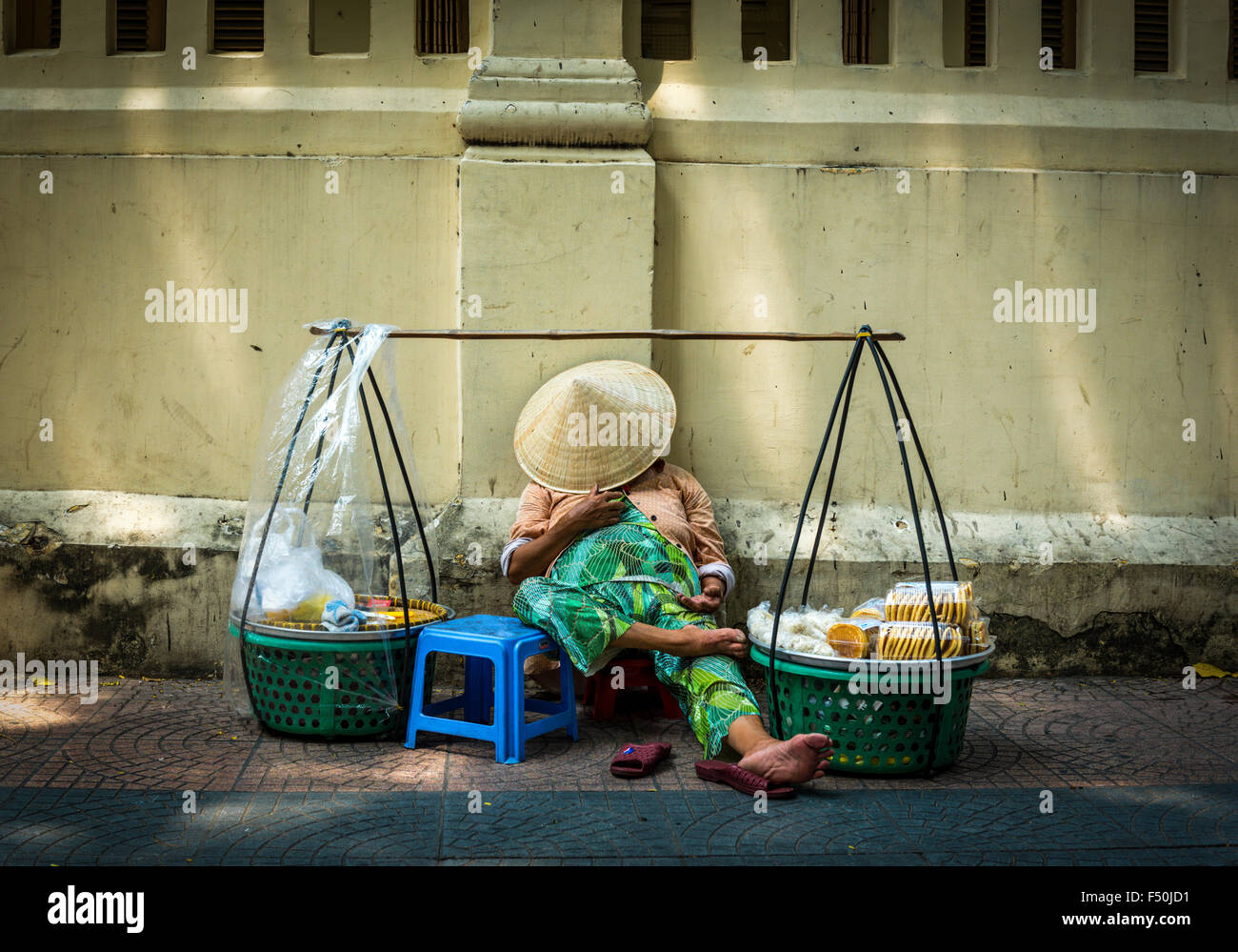 Saigon; Ho-Chi-Minh-Stadt; schlafen Kopf bedeckt von Reis-Hut, Straßenverkäufer; Tag erschossen Stockfoto