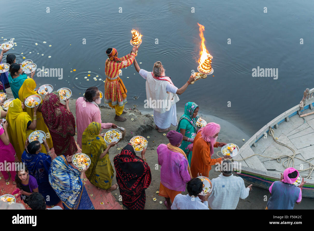 Ein Priester, der Brahmanen, und einige Pilger feiern ein Ritual, Pooja, an den ghats am heiligen Fluss Yamuna, von oben gesehen Stockfoto