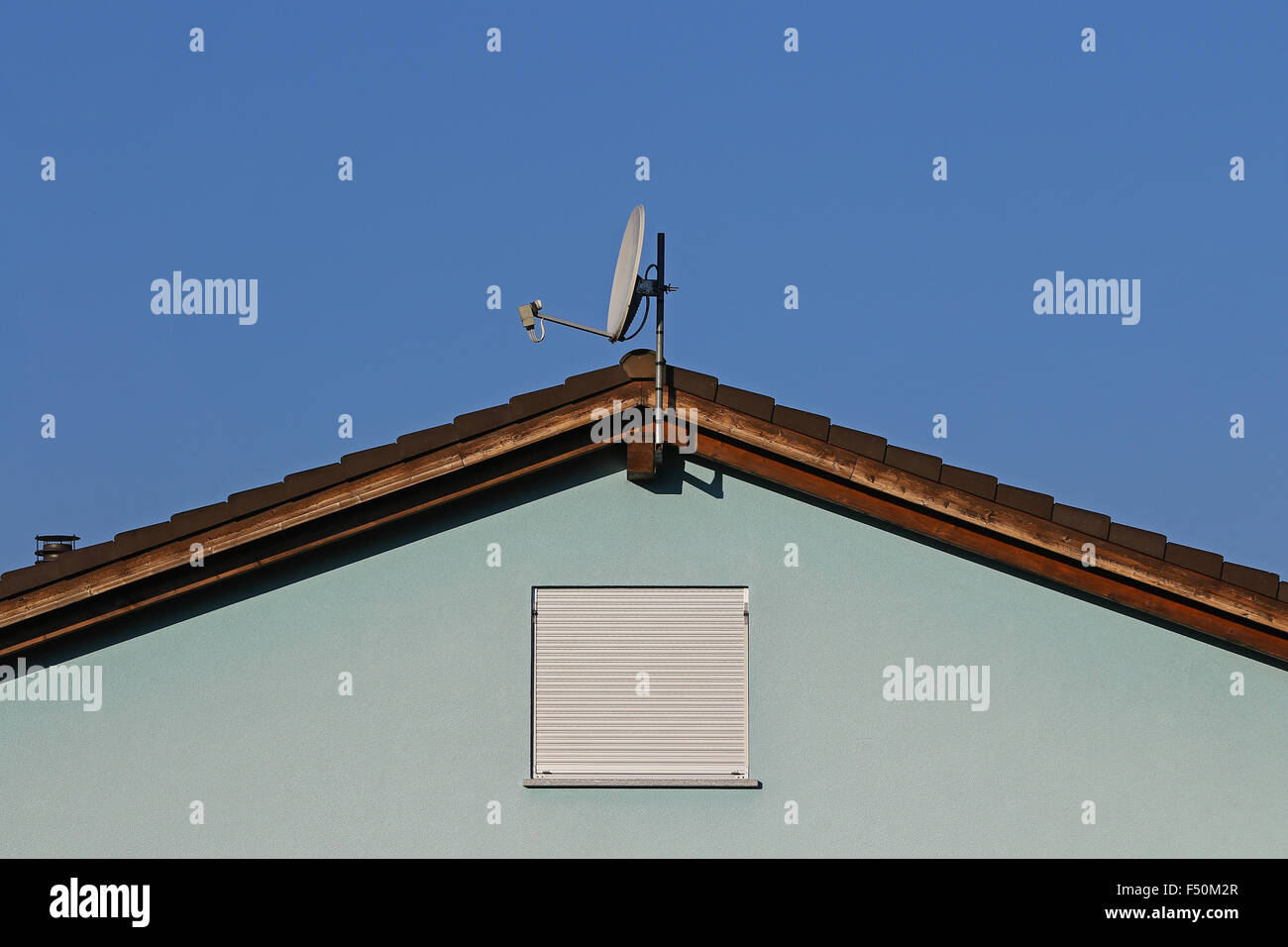 Blau auf blau Fassade mit einfachen Fenster, keramische Fliese Dach und Sat-Schüssel Stockfoto