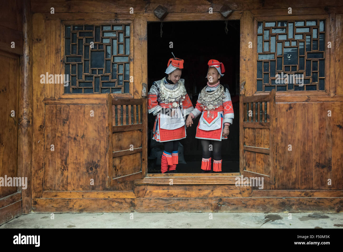 Traditioneller Holzbau und zwei Ge Jia Frau in ethnische Kleidung, Matang Dorf, Guizhou Provinz, China Stockfoto