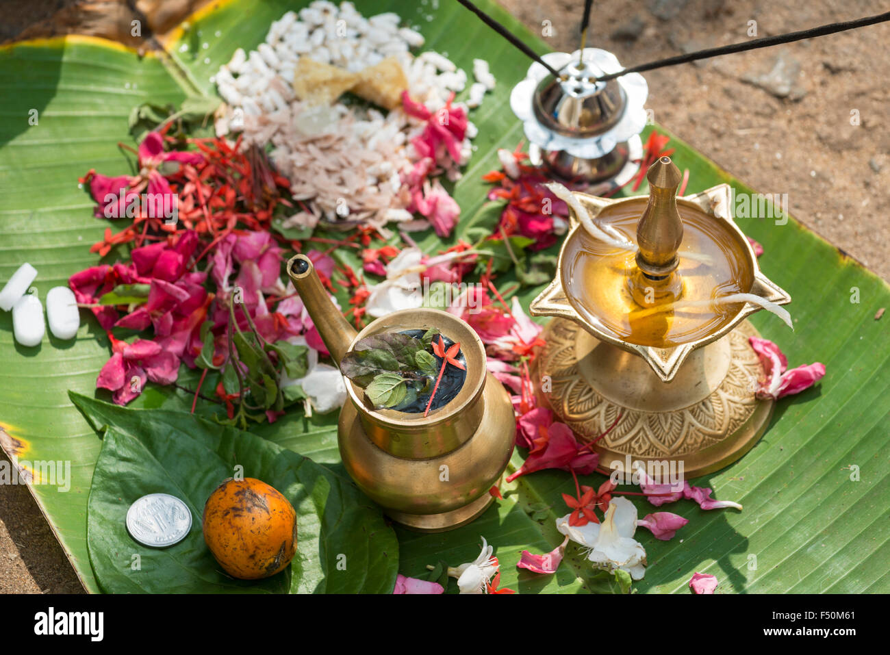 Einen kleinen Altar mit Blumen und öl Lampe auf einem Bananenblatt ist in einer belebten Straße während der pongala Festival Stockfoto