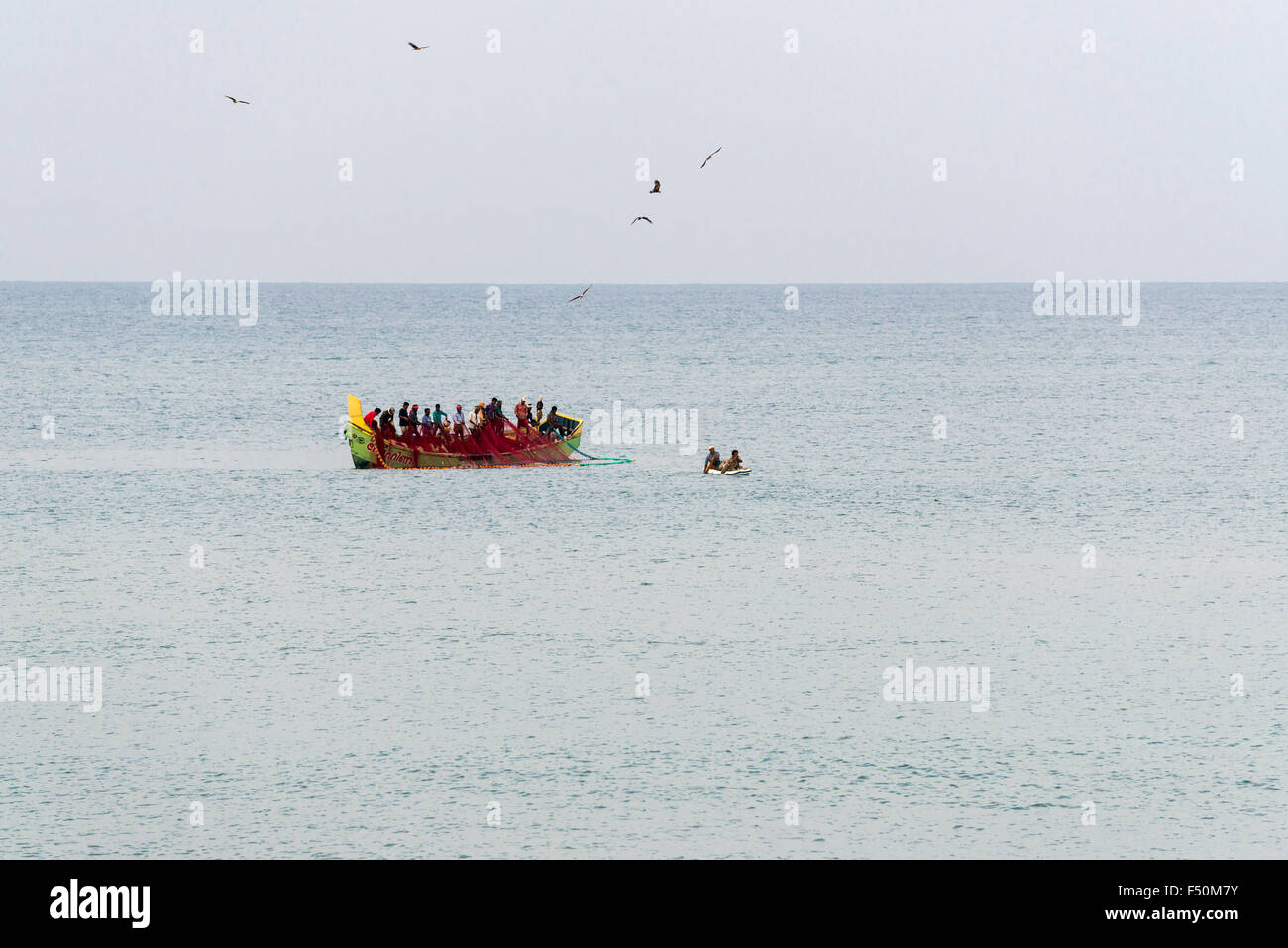Eine Gruppe von Fischern ist Ziehen in den Fischernetzen in ein Schiff auf offener See Stockfoto