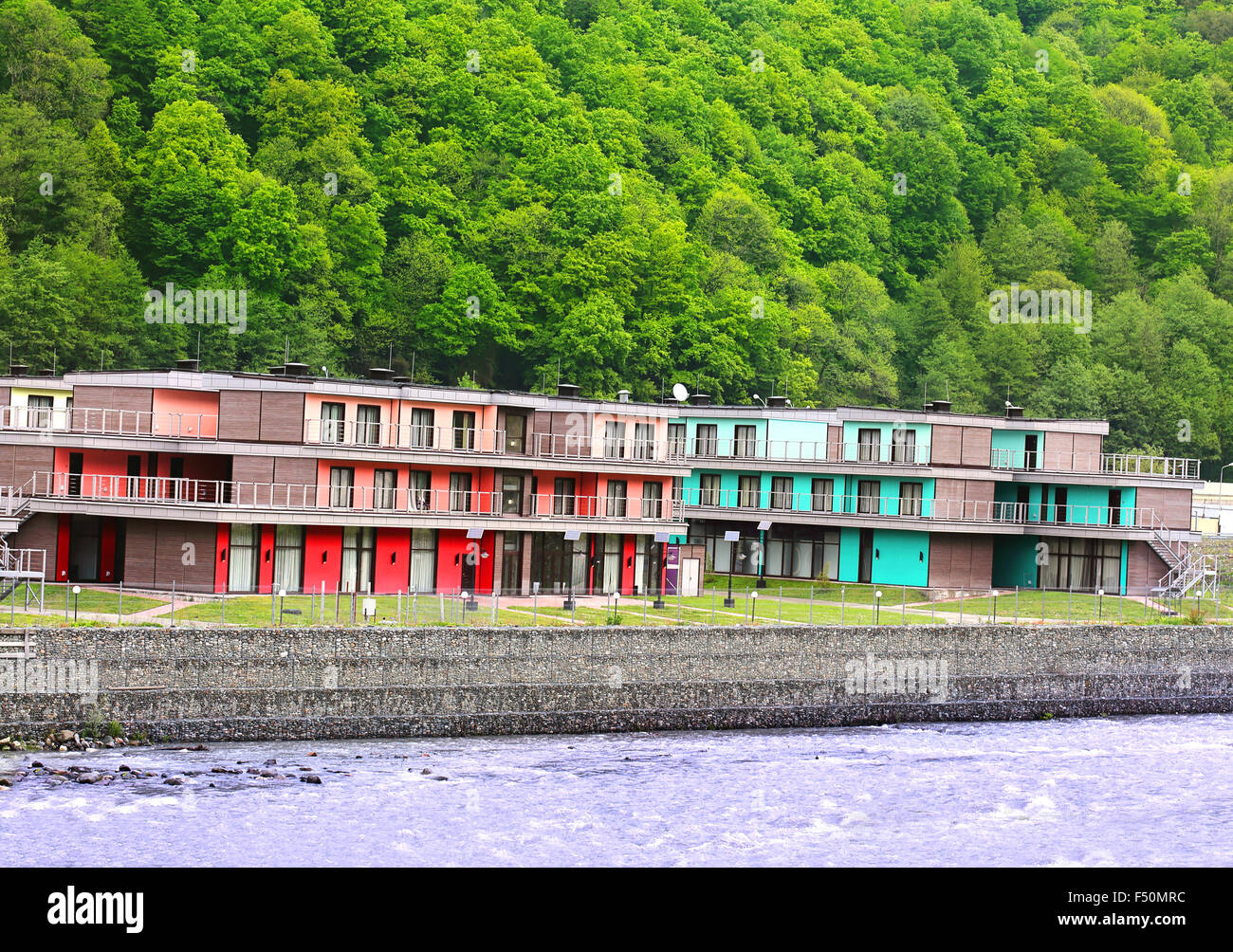Zwei Ferienhäuser am Ufer des Flusses auf dem Hintergrund der Hügel Stockfoto