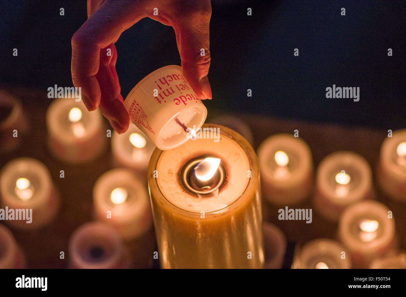 Hand ein Anhänger Beleuchtung eine Kerze für bietet im Inneren der Kirche Unserer Lieben Frau Stockfoto