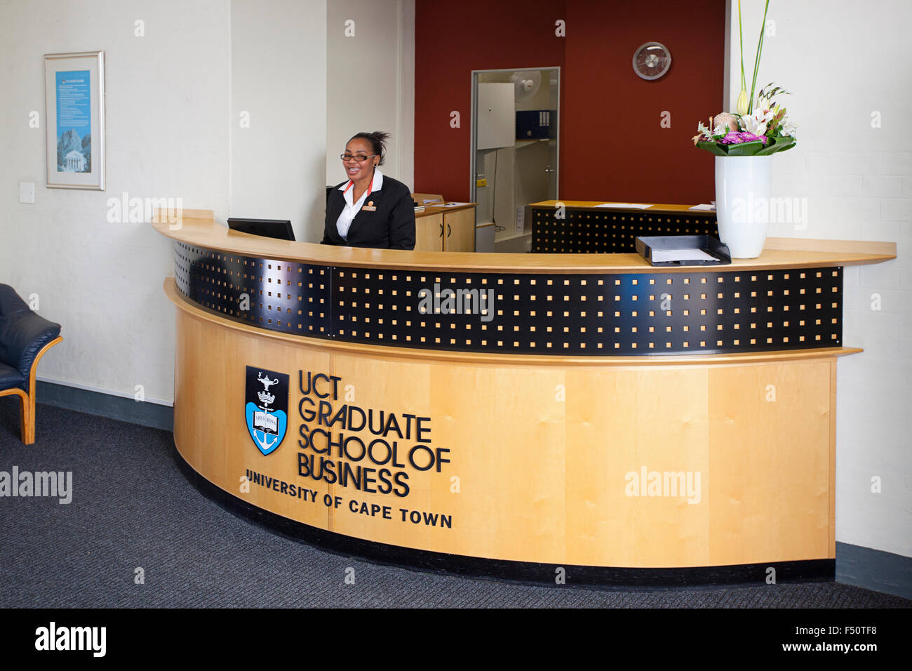 Lächelnde Angestellte an der Rezeption am Eingang der UCT Graduate School of Business Stockfoto